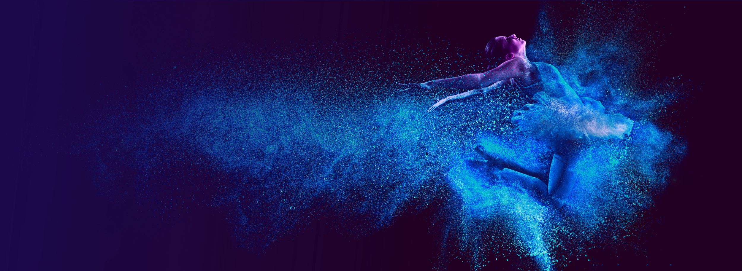 Eine Frau tanzt in der Luft, umgeben von blauem Puder, das in der Luft schwebt und eine magische Atmosphäre schafft.